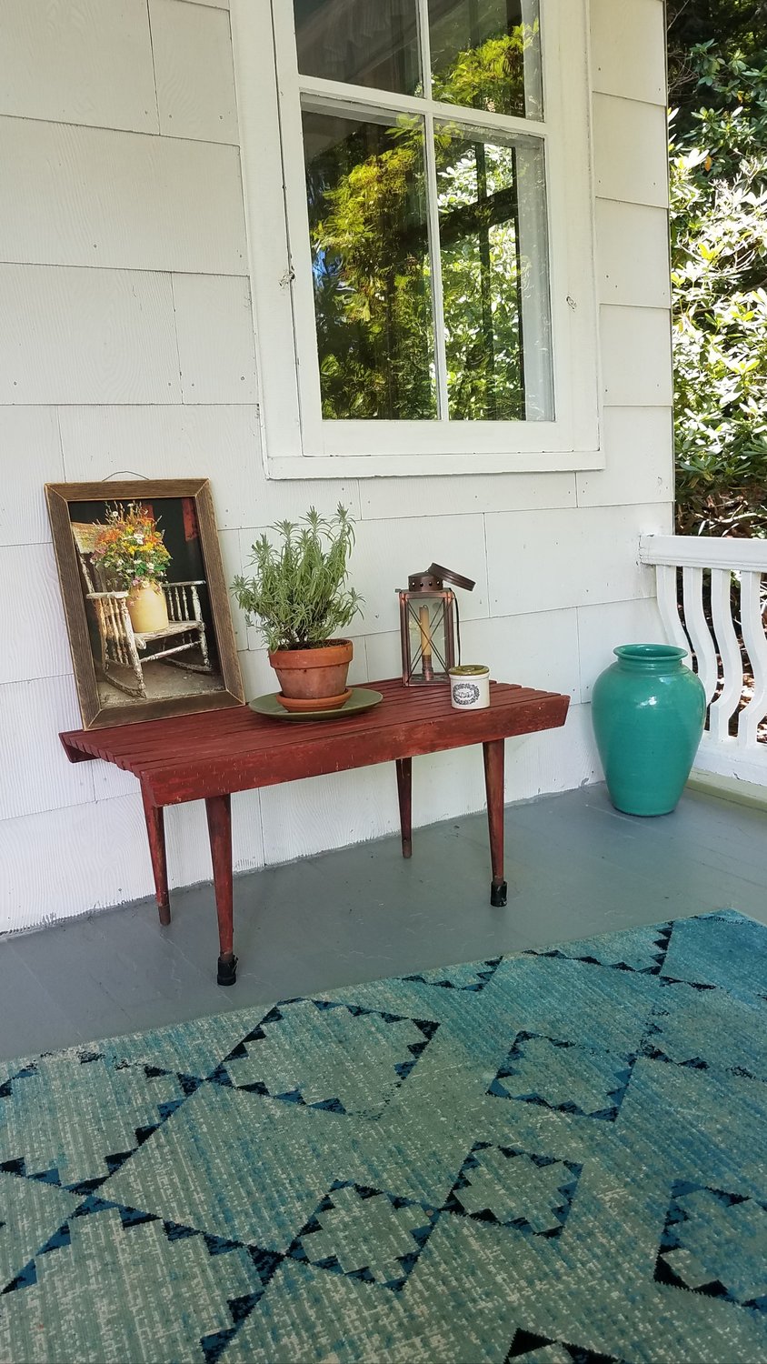 There is nothing fussy about this corner of the porch, which features painted wood floorboards, an indoor/outdoor area rug and a rust-colored vintage slatted-wood table. These decorating elements, combined with simple accessories, come together to create a casual country air...